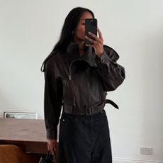 Woman wears black leather jacket, black jeans and carries black bottega bag