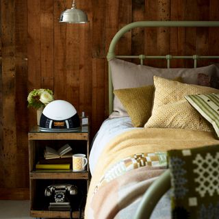 bedroom with wooden wall small wooden cabinet and cushions