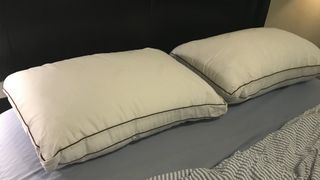 A pair of Saatva Latex Pillows side by side on our tester's bed