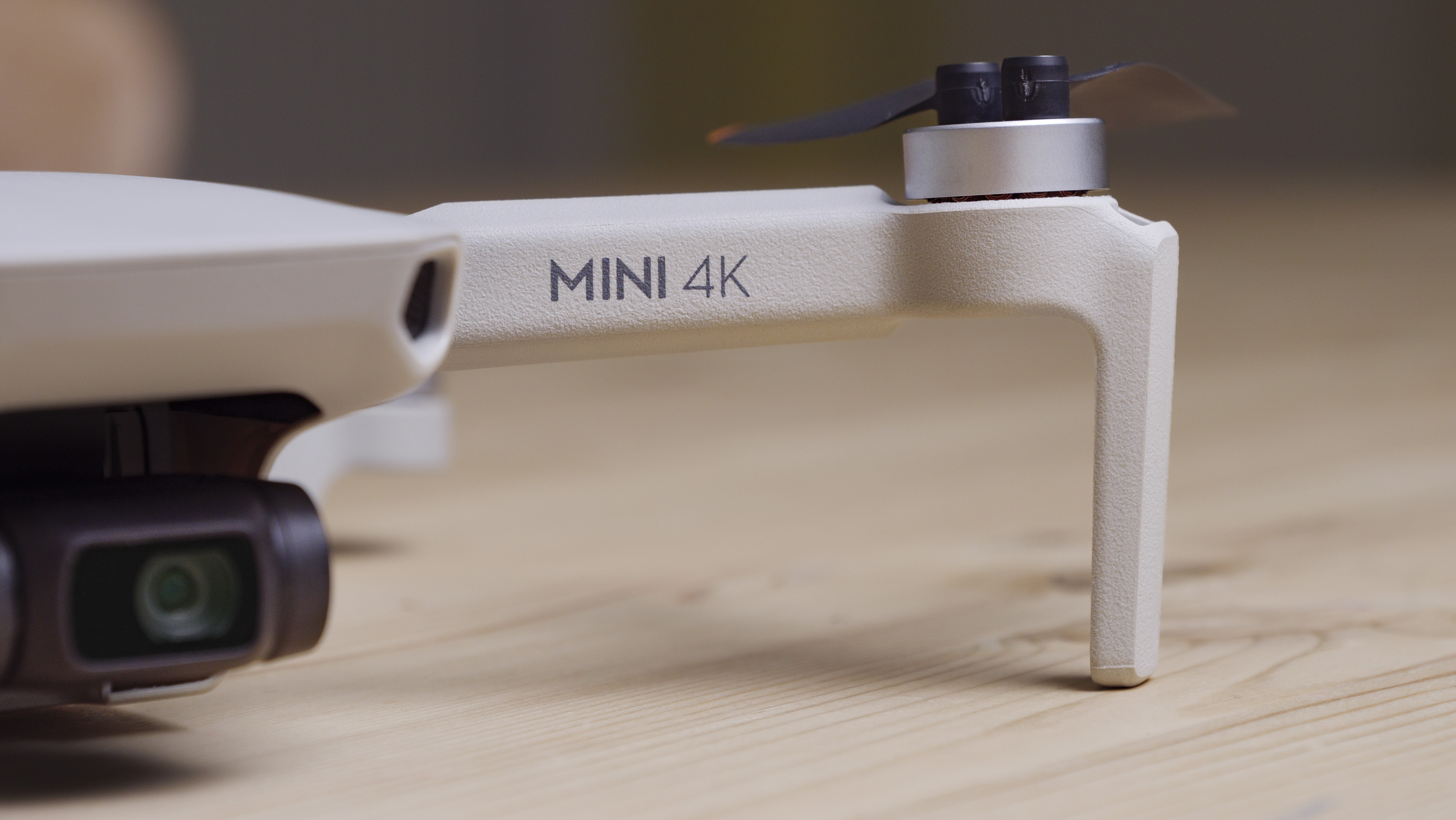 Close up of the DJI Mini 4K beginner drone's arm, on a wooden table