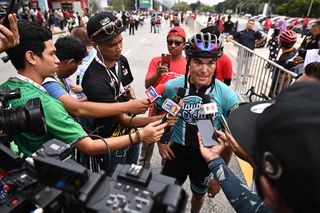 Travis Mccabe talks with reporters after winning stage 3 in Langkawi