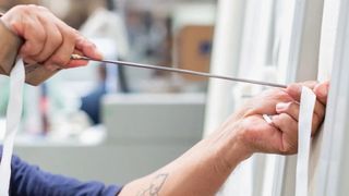 An Avocado employee needle-tufting a mattress by hand