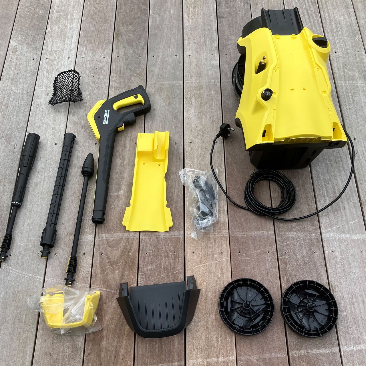 Pressure washer testing on patio, wood and a car