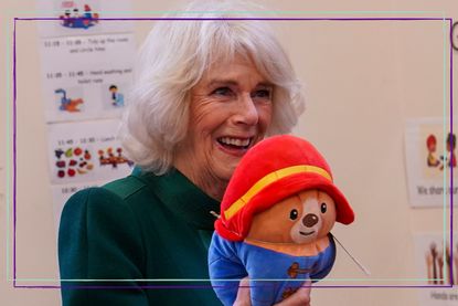 Camilla, Queen Consort smiles as she holds a Paddington Bear toy and attends a special teddy bears picnic at a Barnardo's Nursery in Bow on November 24, 2022 in London, England