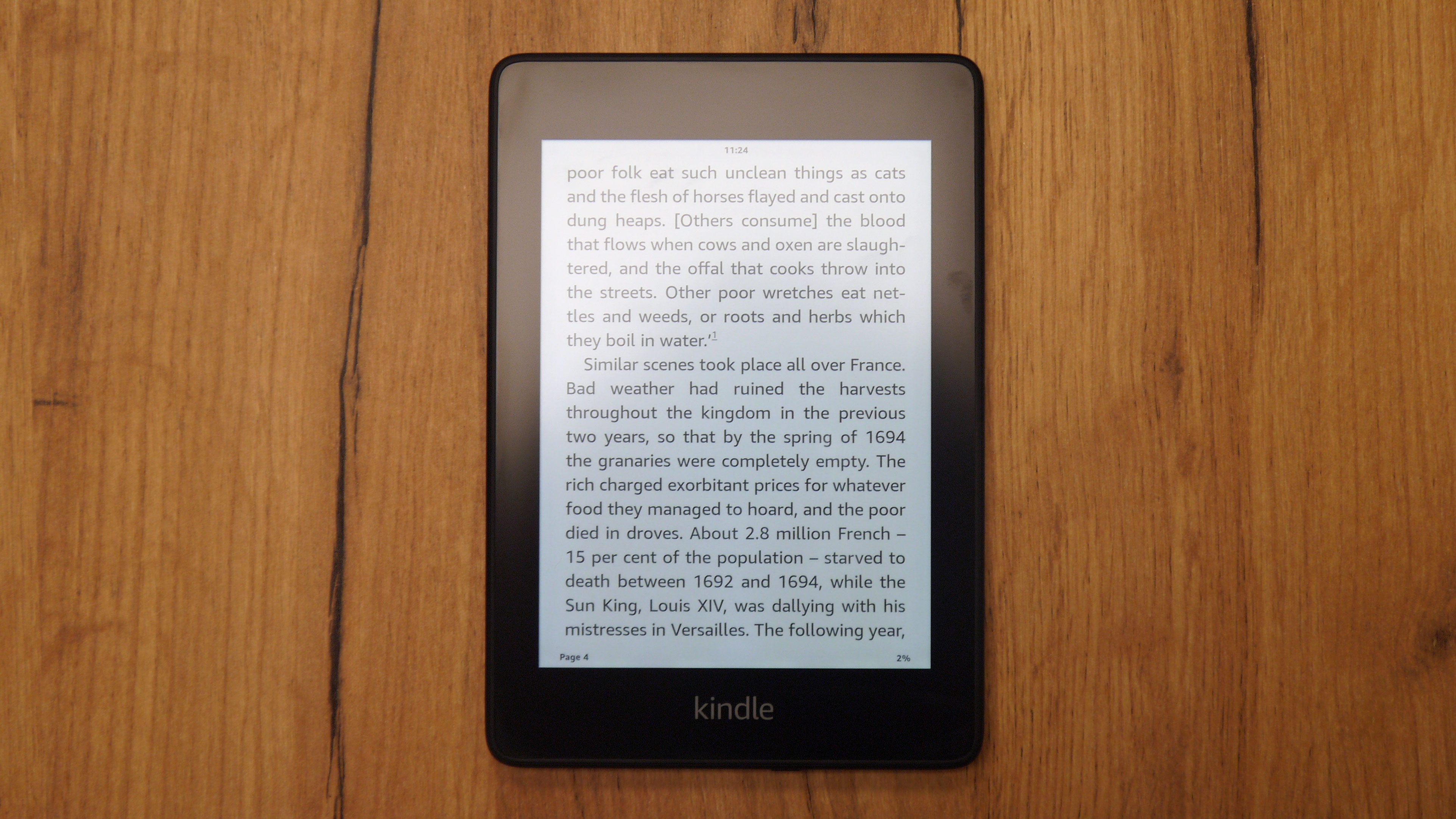 A Kindle Paperwhite sat on a wooden table