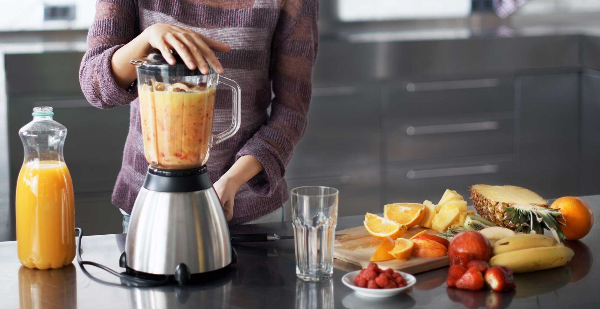 woman cutting up fruit to make a smoothie using. blender to support things you should never pour down drains