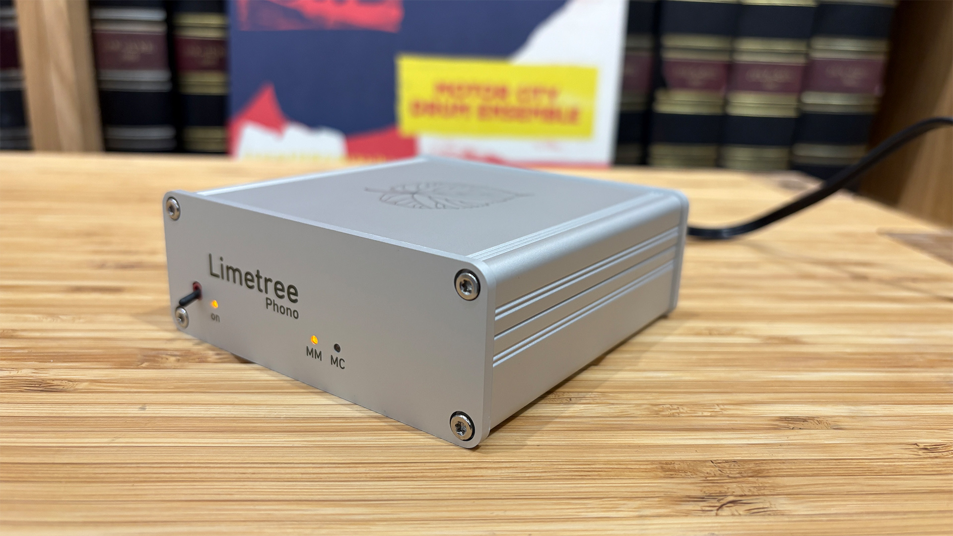 Lindemann Limetree Phono II phono stage on wooden hi-fi rack in front of bookcase