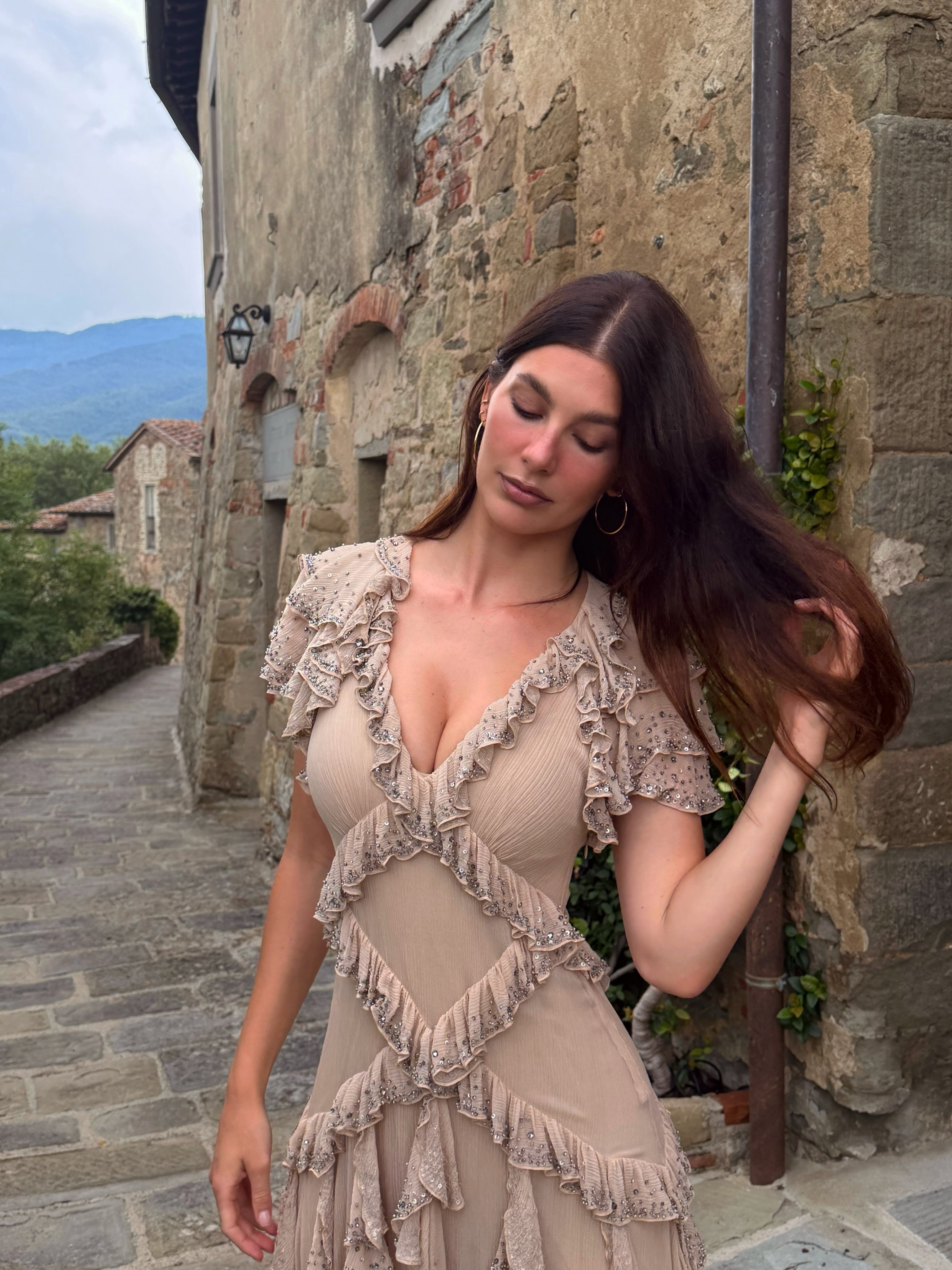 Camila Morrone wears a pink dress with ruffles to a wedding in Tuscany.
