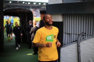 Raheem Sterling heads out for a warm up wearing a yellow Kick It Out t-shirt