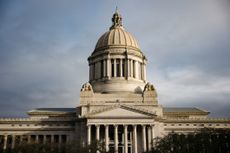 A dramatic view of the Capitol building in Olympia, Washington, the morning sun casting dramatic shadows on the beautiful stone architecture.