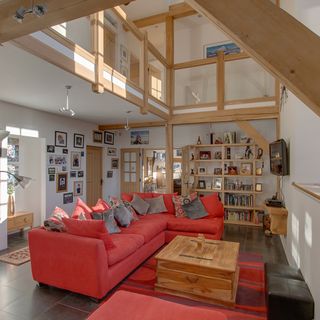 living room with red couch oak beams and white walls