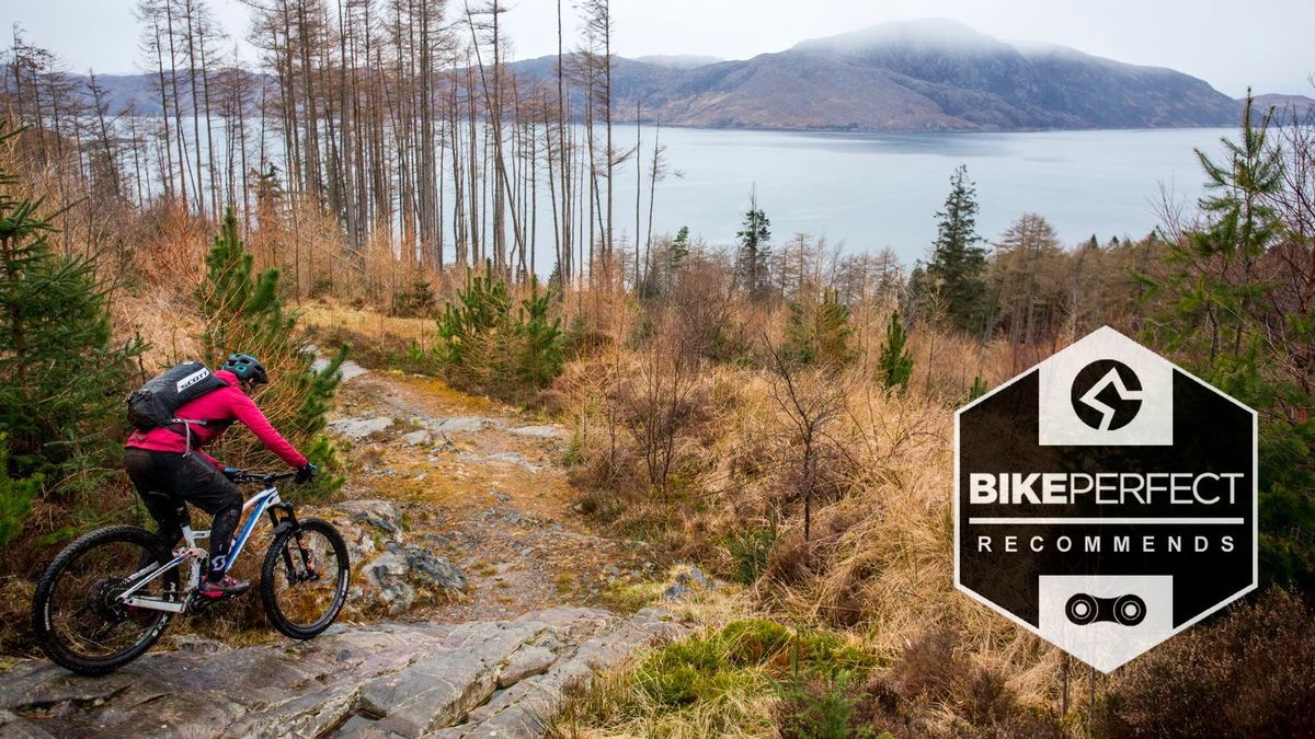 mountain biker riding down rocks by Scottish loch