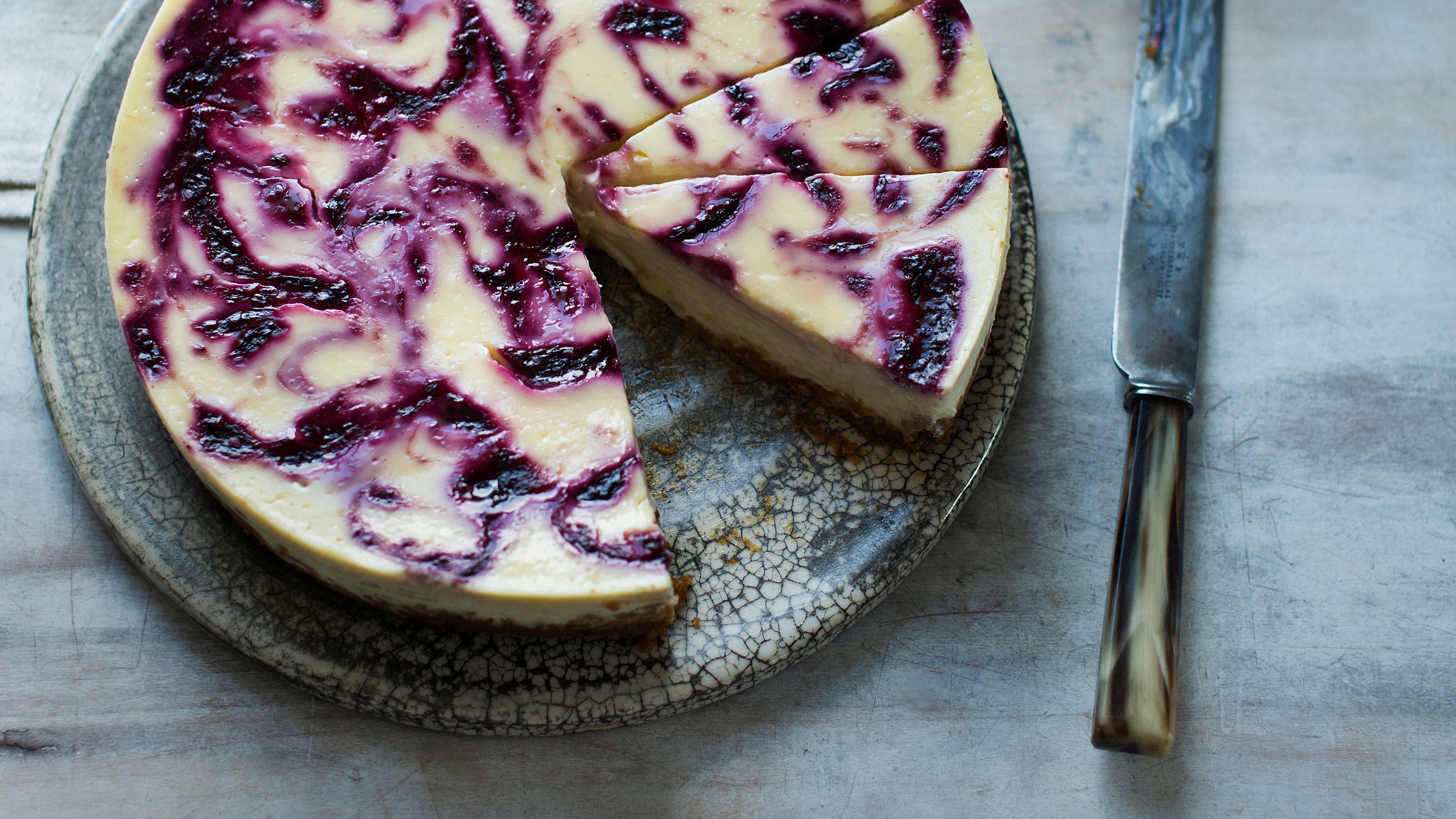 Blackberry ripple cheesecake on a grey mottled plate 