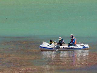 Erich Fleming (l), Ruben Sommaruga and Alex Echeverria row out onto Laguna Lo Encañado – their boat is still awaiting its motor – to collect water samples.