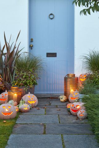 exterior of house with blue painted front door and pumpkins and lanterns