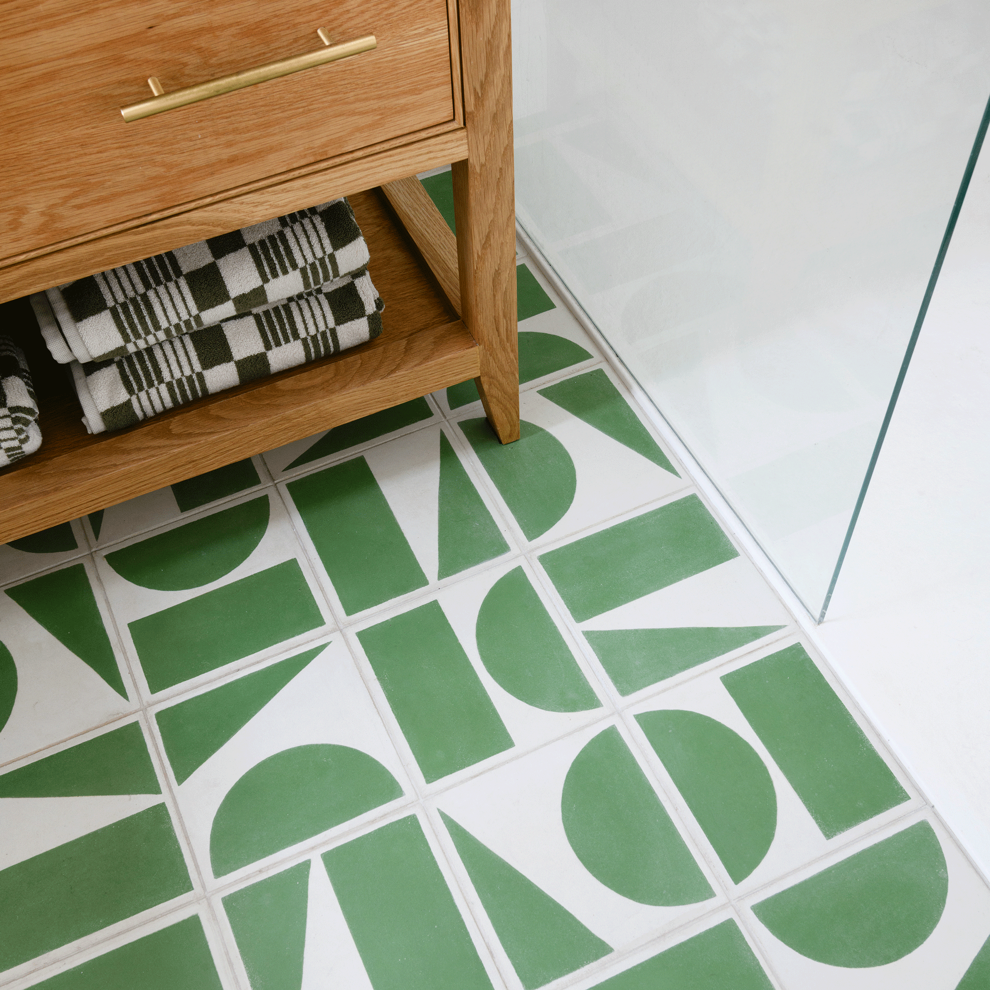 a close up of green and white tiled patterned flooring in a bathroom