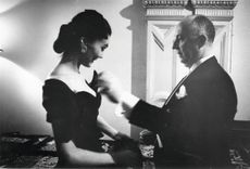 French fashion designer Christian Dior (1905 - 1957) with one of his models backstage at his 1955 fashion show at the Central Hotel, Glasgow, Scotland. The designer flew eight models, six staff and 172 dresses to Scotland for two shows, one in Glasgow and one at the Gleneagles Hotel in Perthshire, to raise money for the Friends of France. (Photo by Thurston Hopkins/Picture Post/Hulton Archive/Getty Images)