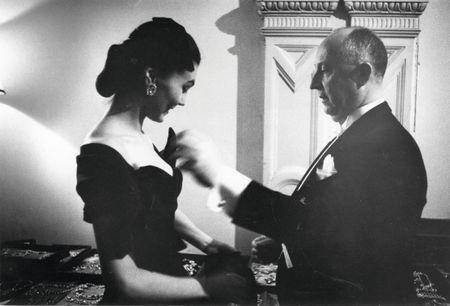 French fashion designer Christian Dior (1905 - 1957) with one of his models backstage at his 1955 fashion show at the Central Hotel, Glasgow, Scotland. The designer flew eight models, six staff and 172 dresses to Scotland for two shows, one in Glasgow and one at the Gleneagles Hotel in Perthshire, to raise money for the Friends of France. (Photo by Thurston Hopkins/Picture Post/Hulton Archive/Getty Images)