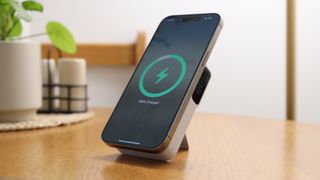Anker MagGo Power Bank (10K) attached to an iPhone 15 Pro Max on a wooden table