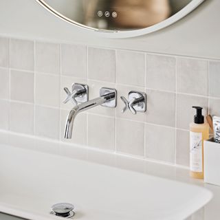 bathroom sink with tiled splashback, tap and LED mirror above