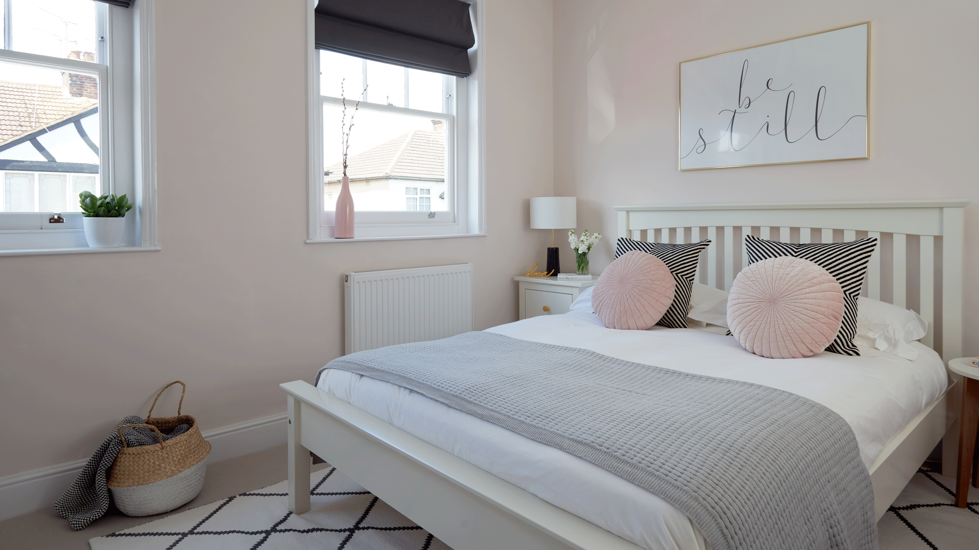 Bed with rug under in neutral colour scheme