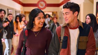 Devi and Paxton smile at each other as they walk through the hallway