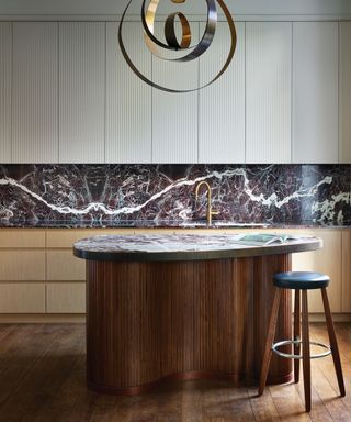 Kitchen with walnut wood cabinetry and marble counter