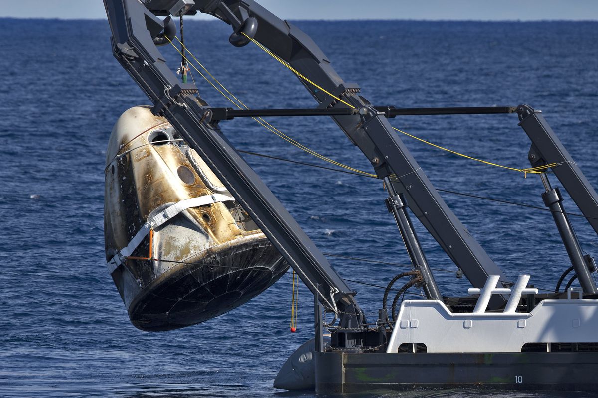 A recovery ship hauls SpaceX&#039;s first Crew Dragon capsule out of the Atlantic Ocean after the spacecraft&#039;s splashdown on March 8, 2019. The capsule was destroyed April 20 during an abort system engine test.