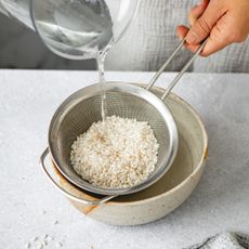 Woman pouring water over rice