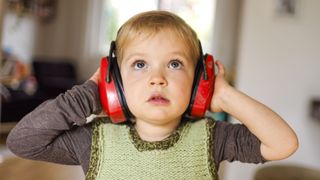 Small child wearing protective headphones