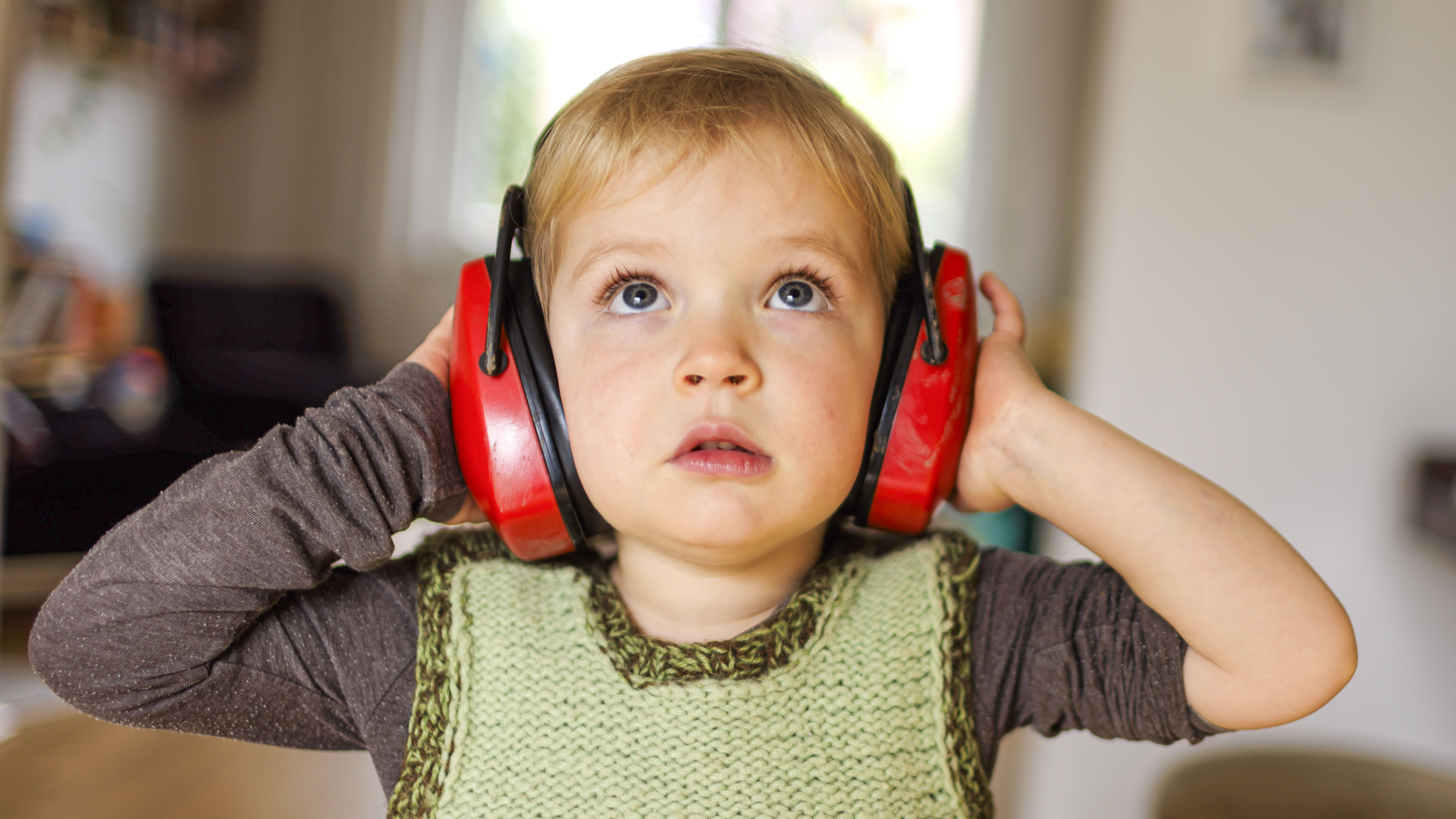 Small child wearing protective headphones
