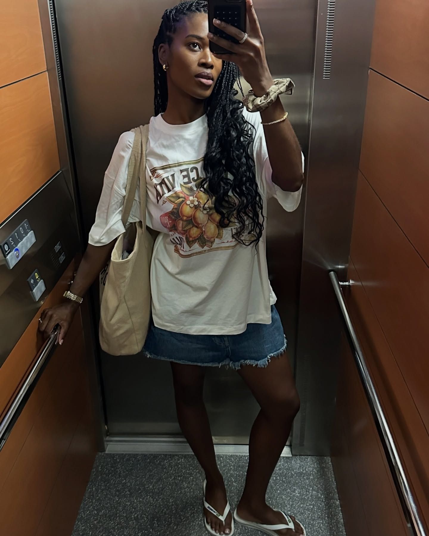 Influencer Marilyn wears white Havaianas, a denim mini skirt, and a graphic tee.