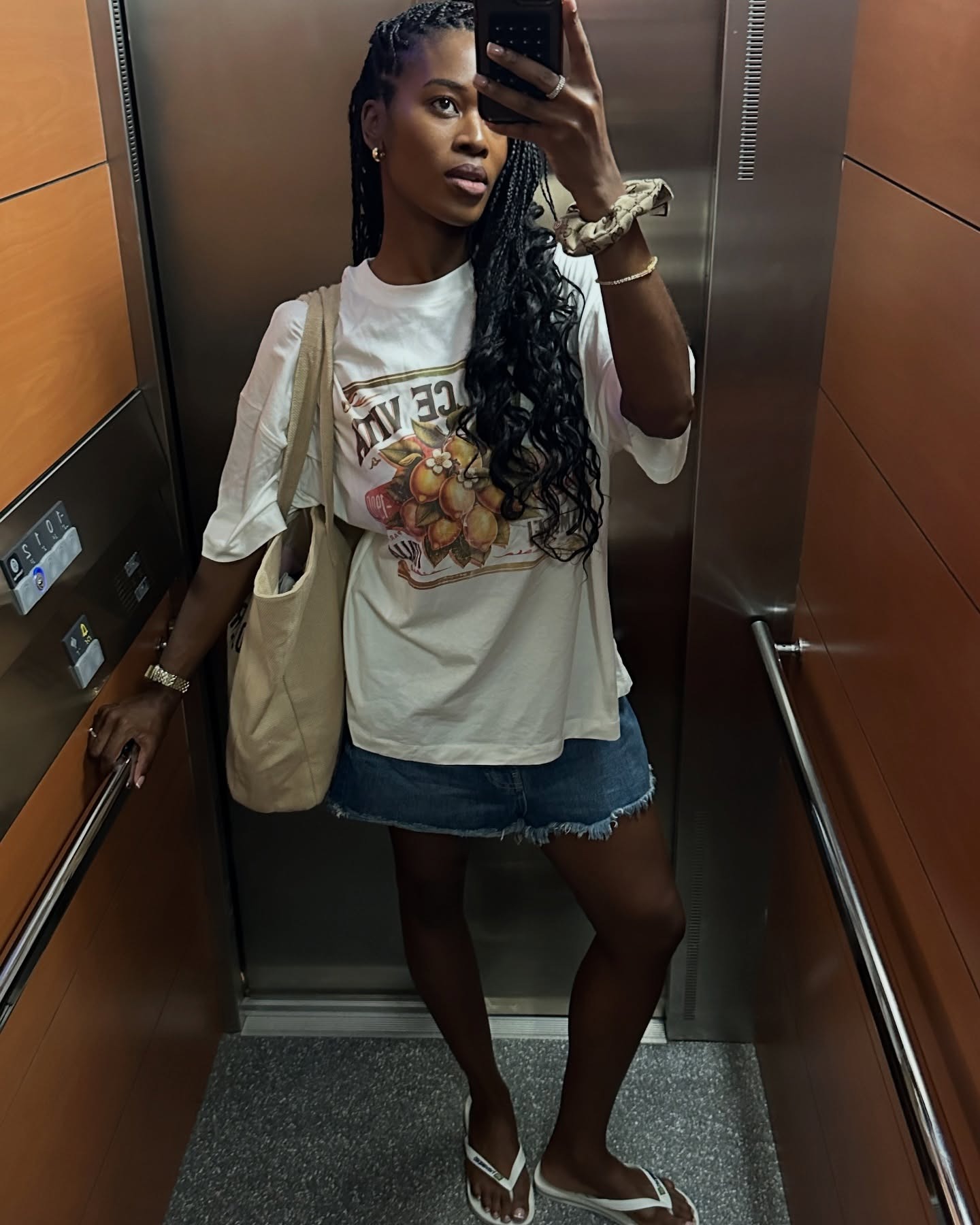 Influencer Marilyn wears white Havaianas, a denim miniskirt, and a graphic tee.