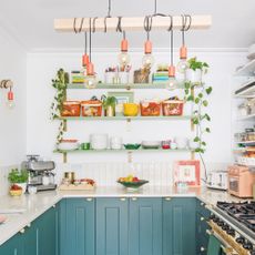 a kitchen with neutral wall tiles, blue painted cabinetry and open shelving