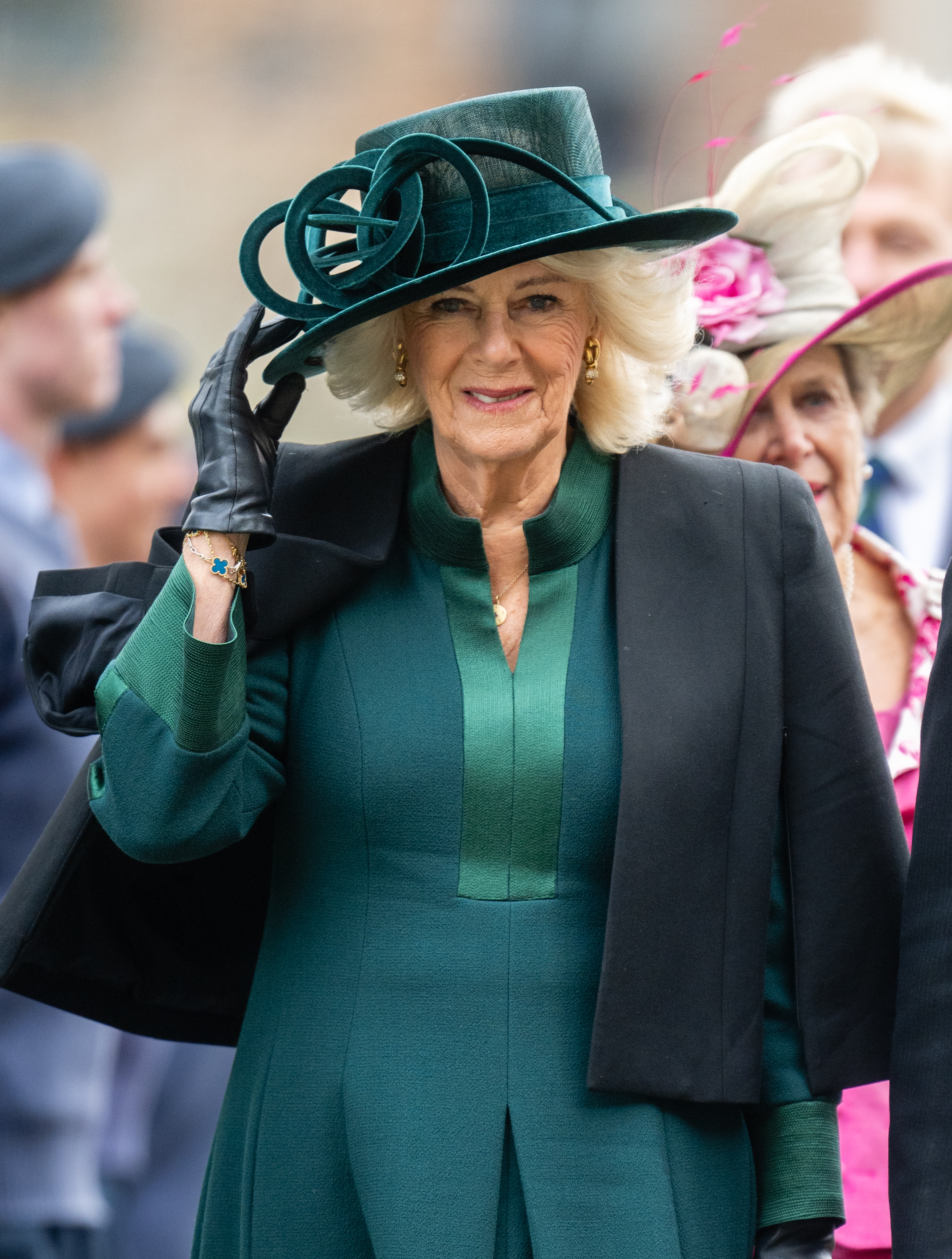 Queen Camilla wearing a green coat and hat with a black cape at Maundy Thursday 2025