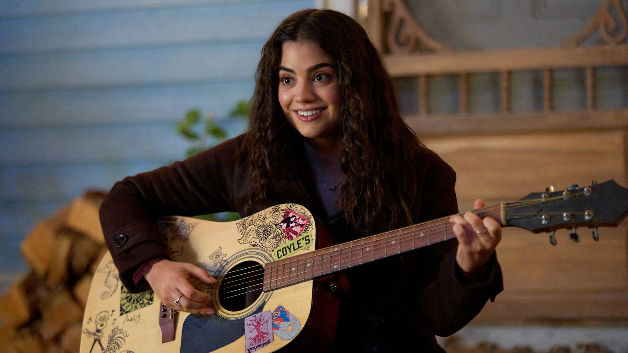 Sadie Laflamme-Snow holds a guitar as Alice in Season 4 of The Way Home. Her hair is down and she is wearing a dark shirt.