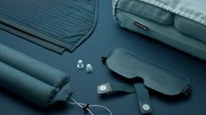 tangerine x buzz travel set consisting of blanket, eye mark, ear buds, neck pillow and lumbar cushion