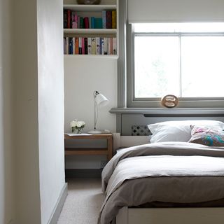 bedroom with white walls and books