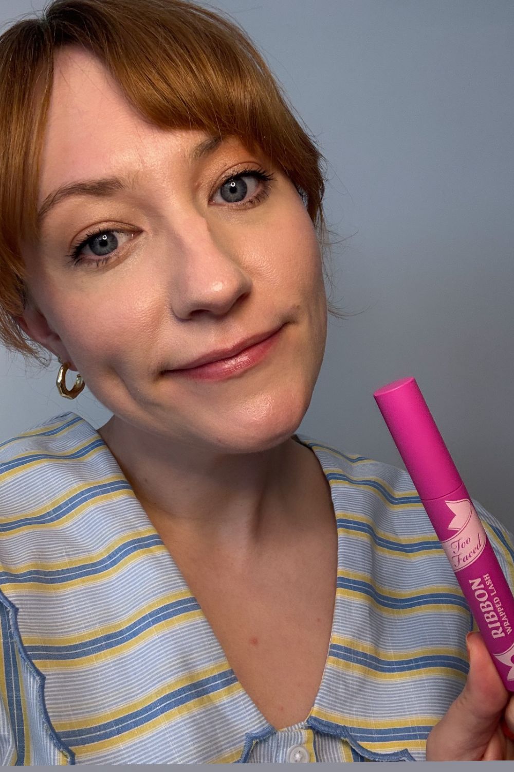 headshot of matilda with a tube of too faced mascara