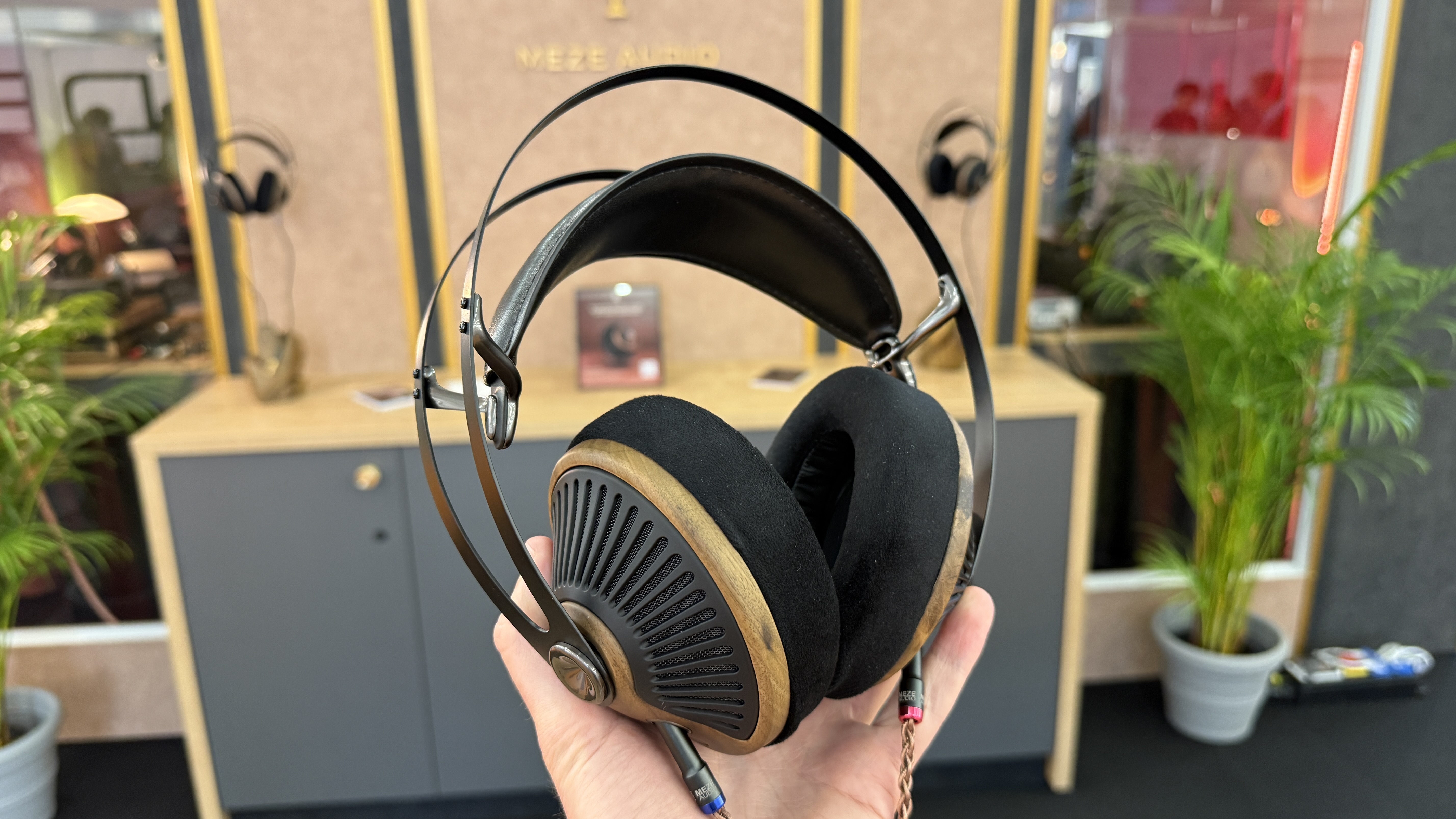 Meze Audio 105 Silva held in a man's hand at the Munich High End Show 2025