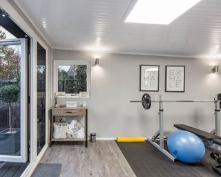 Home gym set-up in man cave space in neutral color palette.