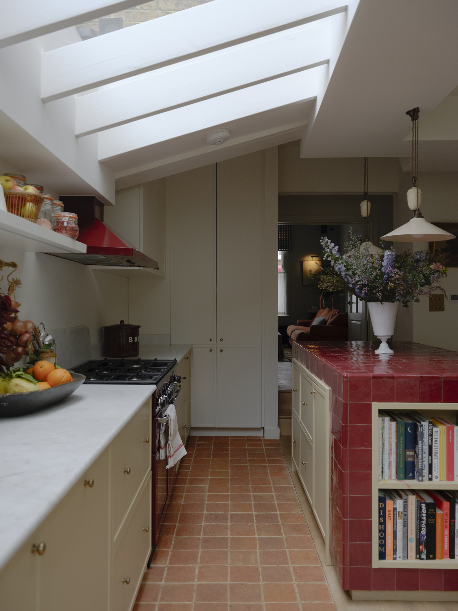 kitchen extension with light grey cabinets and a red tiled kitchen island
