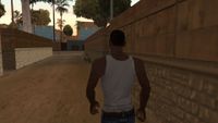CJ walks down an alley toward a bicycle
