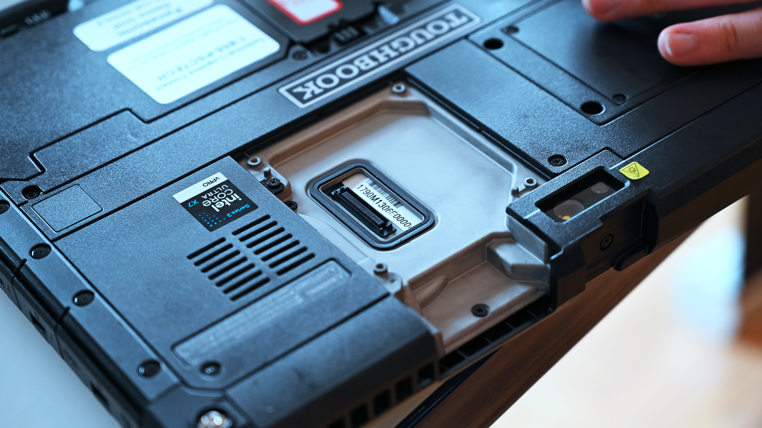 Close-up of the rear panel of a rugged Panasonic TOUGHBOOK G3, displaying expansion ports, cooling vents, an Intel Core Ultra sticker, and serial tag.