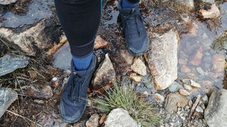 Close up of Arc'Teryx Aerios FL Mid GTX boots worn by a person on rocky ground