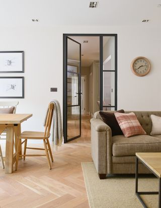 apartment with dining table and living space, view to the hallway, black crittall doors, wooden floors