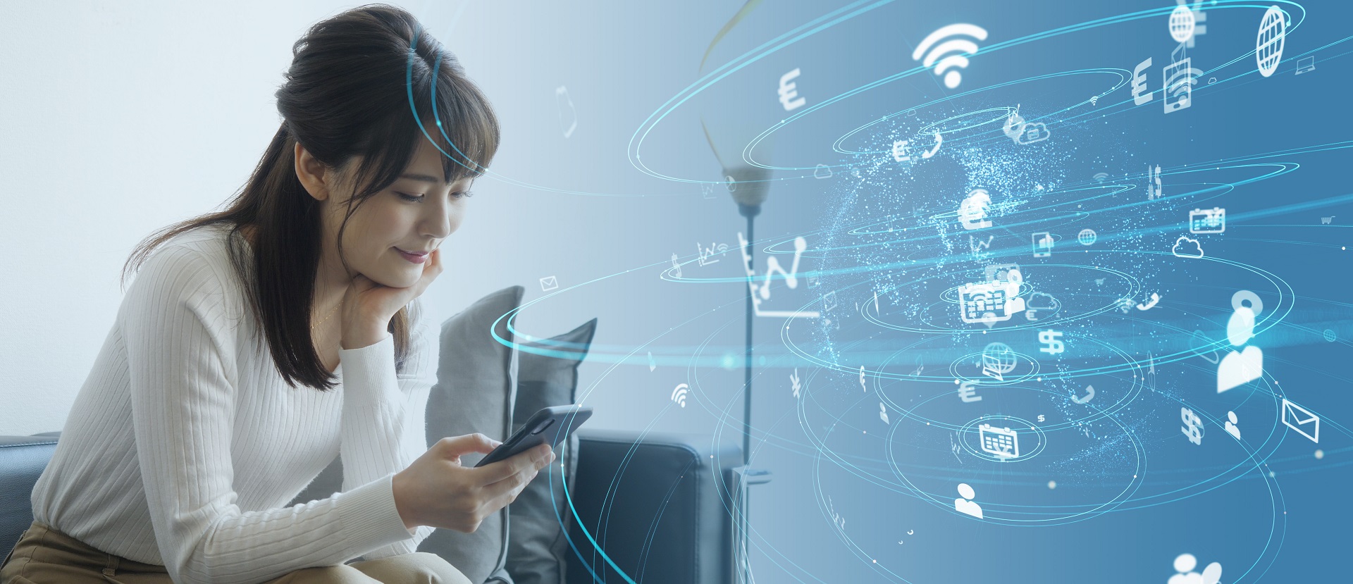 Eine Frau sitzt auf einem Sofa und schaut auf ihr Smartphone