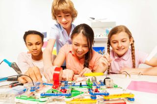  Four students test electric circuits in the classroom lab