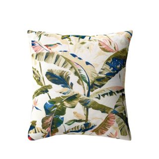 A throw pillow with a green, dark blue, and light pink leafy pattern, with a white base