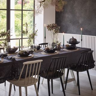 Stacey Solomon x George Home collection laid out in a dining room, including pumpkins, tableware and a ruffled black tablecloth